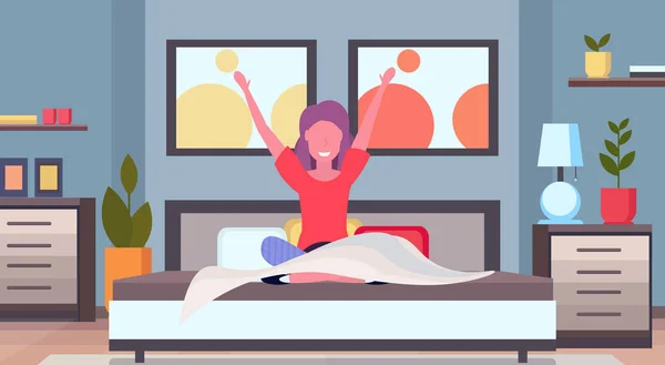 Mujer estirando los brazos despertando en la chica de la mañana sentado en la cama después de levantarse concepto de satisfacción apartamento moderno dormitorio interior plano horizontal — Vector de stock