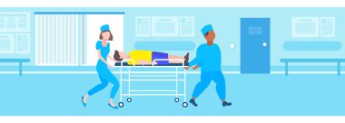 erkek kadın doktorlar hasta hastane yatak sedye tıbbi mix yarış personeli üniformalı adama ameliyathane hastane iç daire tam uzunlukta yatay taşıma taşıma