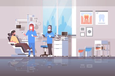 Arap diş hekimi asistanı olarak diş adam hasta yatan diş hekimliği sandalye profesyonel diş ofis modern klinik iç Arapça karakter tam uzunlukta düz yatay sondaj hijab ile