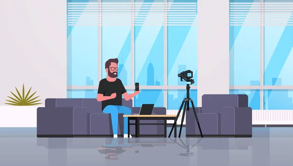 Хлопець технології блогер запис відео на камеру людина показує новий смартфон функціональне тестування концепції блогу сучасний інтер'єр квартири повної довжини горизонтально — стоковий вектор