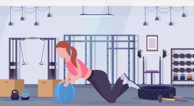 Sportif kadın CrossFit tıp deri top kız ile eğitim kardiyo egzersiz kavramı modern bir spor salonu sağlık stüdyo kulüp iç yatay tam uzunlukta yapıyor