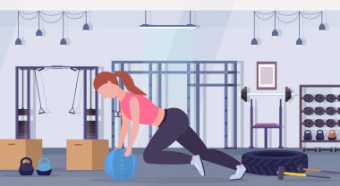 Sportif kadın CrossFit tıp deri top kız ile eğitim kardiyo egzersiz kavramı modern bir spor salonu sağlık stüdyo kulüp iç yatay tam uzunlukta yapıyor