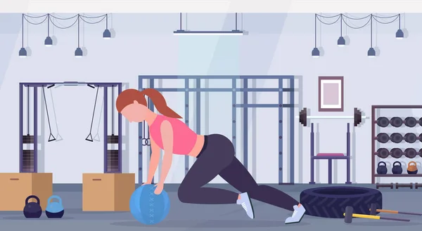 Mulher esportiva fazendo exercícios crossfit com medicina bola de couro menina treinamento cardio treino conceito moderno ginásio saúde estúdio clube interior horizontal comprimento total — Vetor de Stock