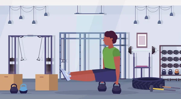ケトルベル アフリカ系アメリカ人の男トレーニング有酸素運動トレーニング コンセプト モダンなジム健康スタジオ クラブ内部水平全長腹筋運動をしている男をスポーツします。 — ストックベクタ