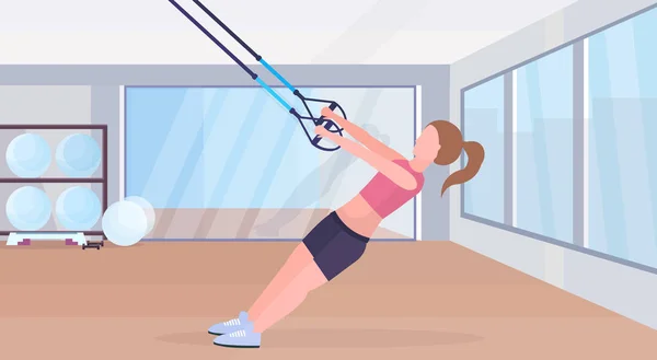 Elastik ipi kız eğitim crossfit egzersiz kavramı modern bir spor salonu studio iç yatay düz tam uzunlukta sportif kadın ile süspansiyon fitness egzersizleri yapıyor kayışlar — Stok Vektör