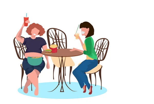 Mujeres delgadas y gordas beber jugo y comer comida rápida durante el encuentro de estilo de vida poco saludable concepto niñas sentado mesa de café personajes de dibujos animados femeninos longitud completa plana horizontal — Archivo Imágenes Vectoriales