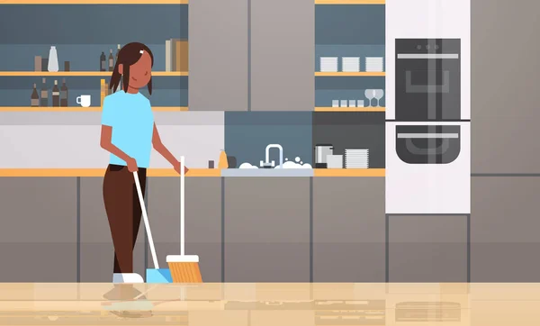 家庭主妇扫地板用扫把和勺非洲美国女孩做家务房子清洁概念现代厨房内部女性字符全长水平 — 图库矢量图片
