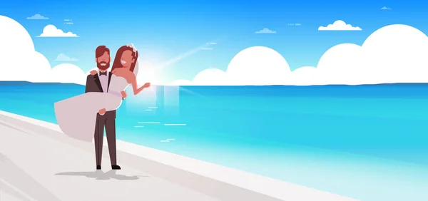 Net getrouwd bruidegom houden bruid op handen romantisch paar staande op zee strand bruiloft dag zomer vakantie concept Seaside achtergrond volledige lengte horizontale plat — Stockvector