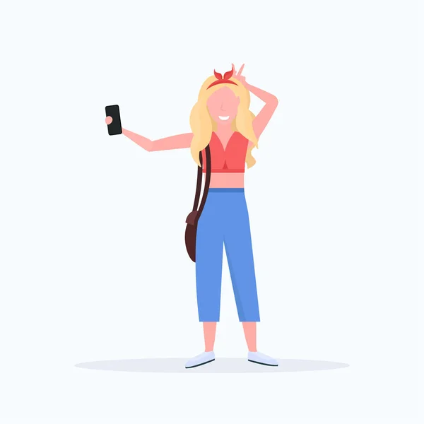 Mulher loira tirando foto selfie na câmera do smartphone personagem de desenho animado feminino posando no fundo branco plana comprimento total — Vetor de Stock