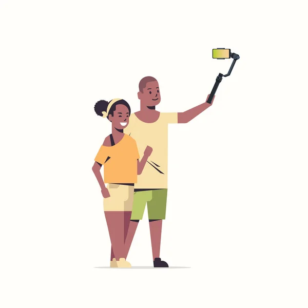 Casal usando selfie stick amantes tirar foto no smartphone câmera afro-americano homem mulher se divertindo masculino feminino personagens de desenhos animados completo comprimento branco fundo — Vetor de Stock