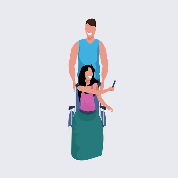 Jovem homem voluntário empurrando mulher sentado em cadeira de rodas cara passear ajudando menina pessoas com deficiência conceito plana comprimento total — Vetor de Stock