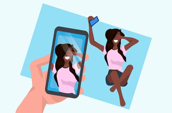 Femme décontractée prenant selfie sur smartphone caméra main tenant téléphone portable avec photo à l'écran afro-américain personnage de dessin animé femme posant plat pleine longueur horizontale — Image vectorielle