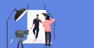 profesyonel fotoğrafçı modern fotoğraf stüdyosu yatay tam uzunlukta düz poz rahat giysiler içinde sakallı adam çekim kameraman kullanarak