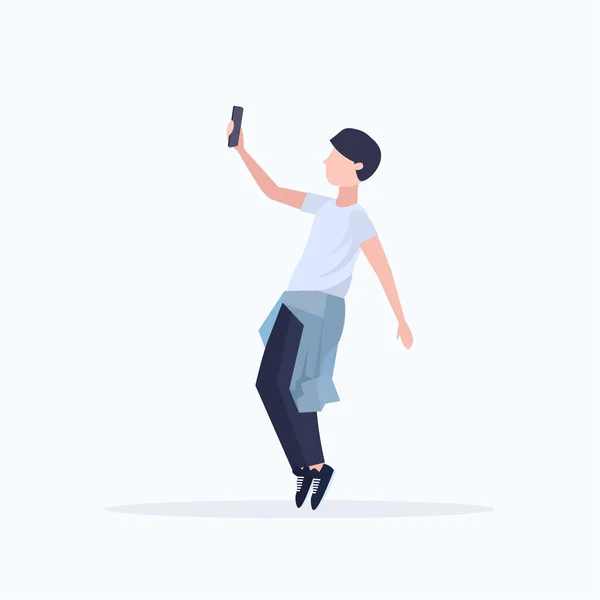 Hombre tomando foto selfie en la cámara del teléfono inteligente personaje de dibujos animados masculinos casual posando fondo blanco de longitud completa plana — Archivo Imágenes Vectoriales