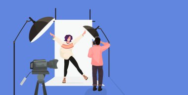 modern fotoğraf stüdyosu yatay tam uzunlukta düz poz ellerini yükselterek güzel seksi kadın model çekim kameraman kullanarak profesyonel fotoğrafçı