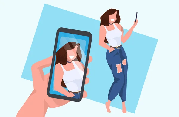 Casual woman taking selfie on smartphone camera hand holding cellphone with photo on screen female cartoon character posing flat full length horizontal — Stock Vector