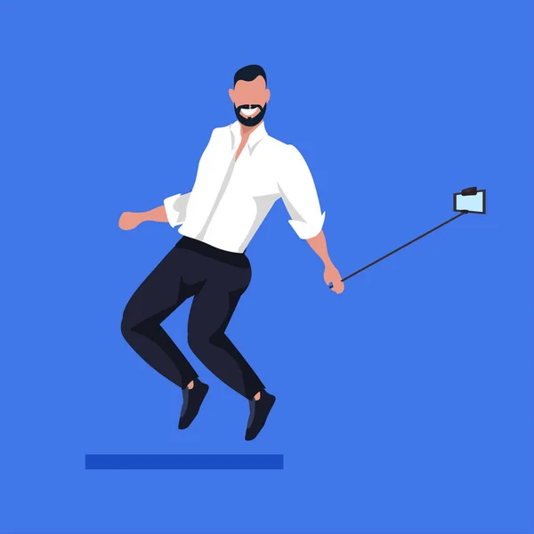 Бизнесмен с помощью селфи-палки фотографирует на смартфоне бизнесмена в формальной одежде мужского персонажа мультфильма, позирующего на всю длину — стоковый вектор