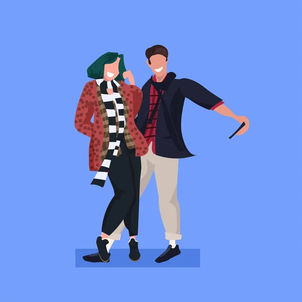 Casal tirando foto selfie na câmera do smartphone homem casual mulher de pé juntos personagens de desenhos animados femininos posando fundo azul plana comprimento total — Vetor de Stock