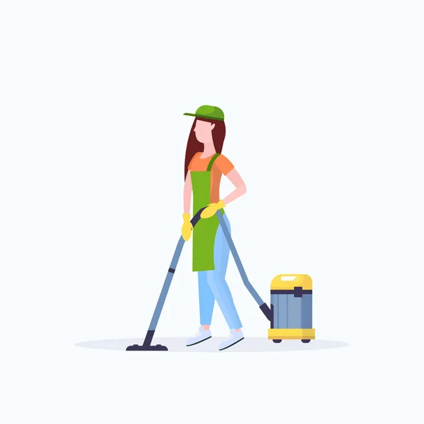Γυναίκα με ποδιά χρησιμοποιώντας ηλεκτρική σκούπα γυναίκα επιστάτης καθαρισμού υπηρεσία δαπέδου έννοια επίπεδη πλήρους μήκους λευκό φόντο — Διανυσματικό Αρχείο