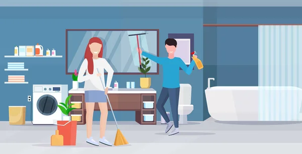 Couple doing housework together man wiping glass mirror woman sweeping floor with broom cleaning housekeeping concept modern bathroom interior full length horizontal — Stock Vector