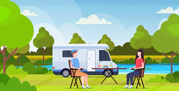 Couple assis à la table près du camping famille remorque camion caravane voiture homme femme passer du temps ensembleson vacances d'été concept beautful nature paysage fond plat pleine longueur horizontale — Image vectorielle