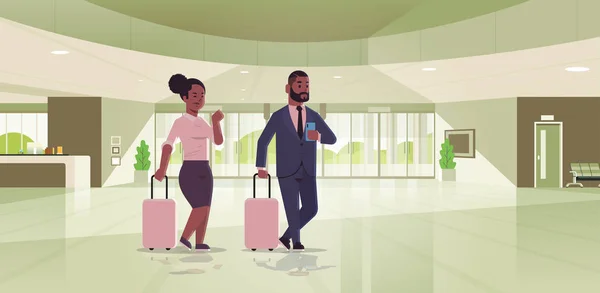 スーツケースを持つレセプションエリアに立つ荷物カップルを持つビジネスマンアフリカ系アメリカ人ビジネスマン女性がスーツケースを持っている現代的なロビーホテルホールインテリアフラット水平全長 — ストックベクタ