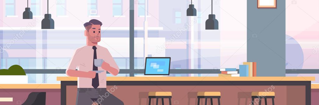 businessman sitting on chair at bar counter with laptop coffee break concept business man drinking cappuccino modern cafe interior flat portrait horizontal