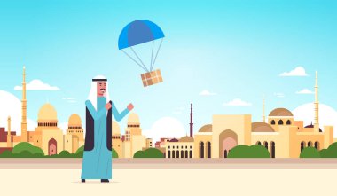 arap adam paraşüt nakliye paketi hava posta ekspres posta teslim konsepti nabawi cami bina müslüman cityscape arka plan tam uzunlukta yatay ile düşen parsel kutusu yakalamak