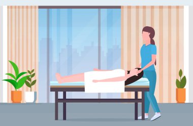 masaj yatağında yatan kadın afro-amerikan masöz şifa tedavisi masaj yaralı hasta manuel fizik tedavi rehabilitasyon kavramı modern klinik spa salonu iç tam uzunlukta yapıyor