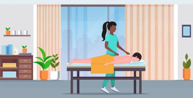 afro-amerikan akupunkturcu tutan iğne adam hasta akupunktur tedavi tedavileri alternatif tıp kavramı modern spa salonu iç tam uzunlukta yatay alma