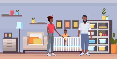 baba anne ve beşikte yeni doğan bebek birlikte mutlu afrikalı-amerikalı aile ebeveynlik kavramı modern bebek yatak odası iç tam uzunlukta yatay düz eğlenmek