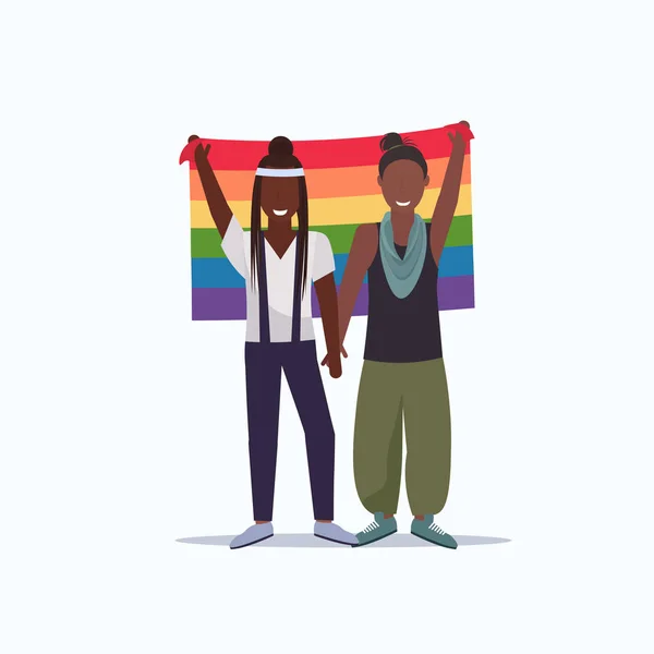 Donne coppia tenendo bandiera arcobaleno amore parata lgbt orgoglio festival concetto due afro-americano lesbiche femmina personaggi dei cartoni animati in piedi insieme a tutta la lunghezza piatta — Vettoriale Stock