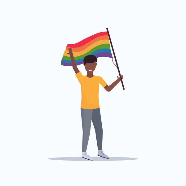 Pria gay memegang bendera pelangi lgbt cinta parade konsep festival kebanggaan tersenyum african Amerika karakter kartun laki-laki panjang datar - Stok Vektor