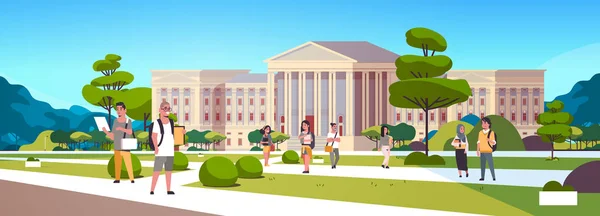 Молода група студентів мікстейпу в кампусі Концепція освіти коледжу друзі розслабляються і ходять перед університетським будівлею зовні горизонтальна повна довжина — стоковий вектор