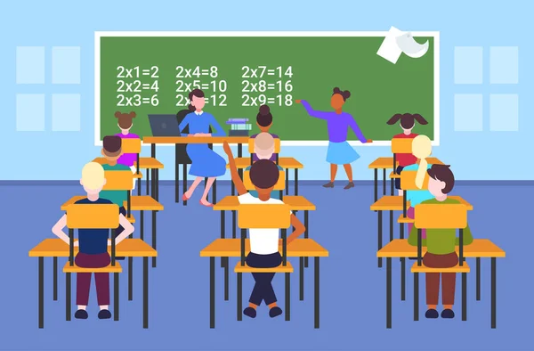 Enseignante avec des élèves assis à des bureaux regardant une écolière résoudre un problème de mathématiques au tableau de bord leçon d'école concept d'éducation école moderne salle de classe intérieur plat pleine longueur horizontale — Image vectorielle