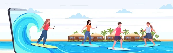 Surferów za pomocą telefonów komórkowych surfing na fale mężczyzn kobiet na deski surfingowe lato na Surfboard technologia koncepcja smartphone ekran online komórkowy na pełnym poziomie — Wektor stockowy