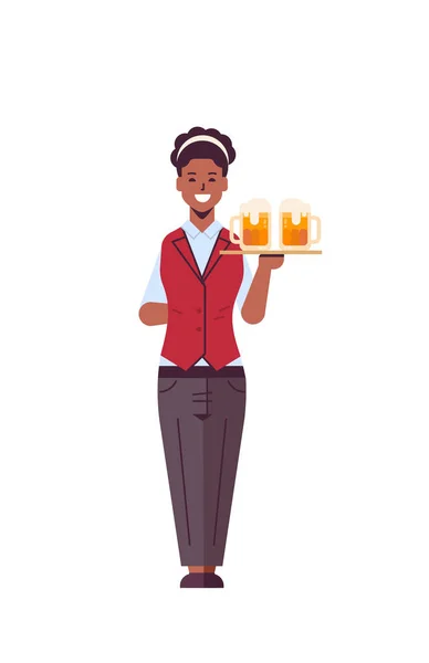 Garçonete profissional segurando bandeja servindo com dois copos de cerveja afro-americana mulher restaurante trabalhador em uniforme carregando bebidas alcoólicas plano de comprimento total fundo branco vertical — Vetor de Stock