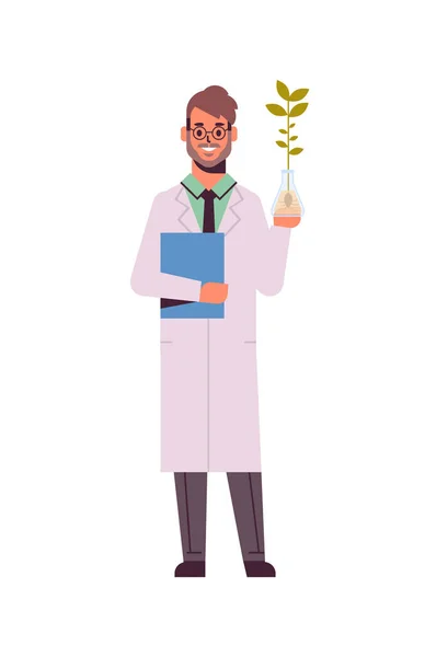 Cientista masculino examinando amostra de plantas em homem tubo de ensaio com prancheta em uniforme fazendo experimento em laboratório genético ciência química conceito vertical comprimento total plana —  Vetores de Stock