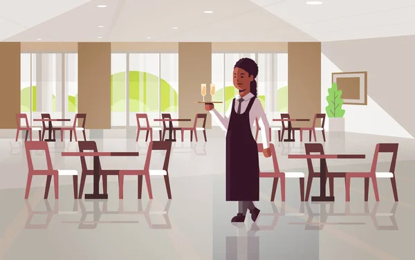专业女服务员拿着服务托盘与两杯香槟非洲美国女餐厅工人在围裙携带酒精饮料现代咖啡馆内部平全长水平 — 图库矢量图片