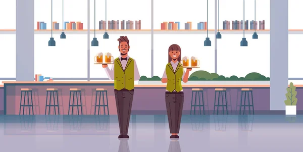 Profesionální číšníci dvojice držící podnosy s brýlemi z pivní ženy muž restaurace zaměstnanci v uniformě nosit alkohol nápoje moderní hospoda — Stockový vektor