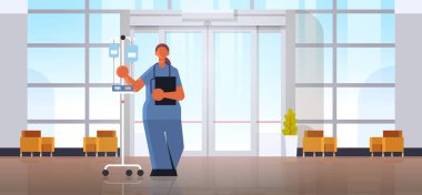 üniforma tutan damlalık tıp sağlık kavramı modern hastane tıp kliniği salonu iç tam uzunlukta yatay düz kadın doktor anesteziuzmanı