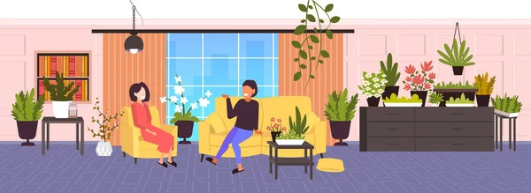 Chicas discutiendo durante la reunión de mujeres relajarse en la sala de estar moderna con plantas de la casa verde interior — Archivo Imágenes Vectoriales