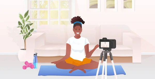 Žena fitness trenér nahrávání videa blog pomocí fotoaparátu na stativ živé streaming blogování cvičení koncept — Stockový vektor