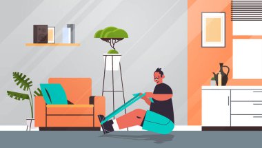 Adam evde direniş bandıyla egzersiz yapıyor. Spor yapıyor, sağlıklı yaşam tarzı eğitimi alıyor.