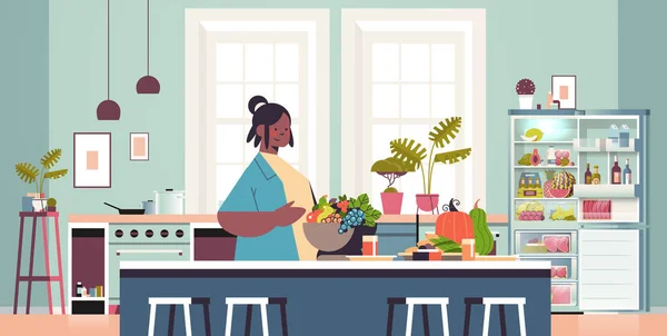 Lycklig kvinna förbereda hälsosam mat hemma matlagning koncept modernt kök interiör — Stock vektor