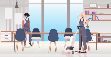 Profesyonel temizlikçi çift yarış hizmetlilerini temizleme ekipmanlarını kullanarak karıştırıyor.