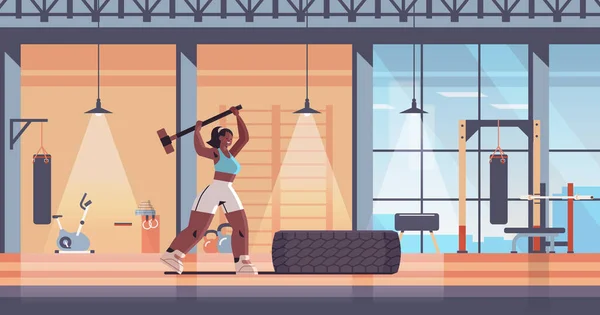 Esportista batendo pneu com hummer menina fazendo exercícios duros trabalhando fora fitness treinamento estilo de vida saudável — Vetor de Stock