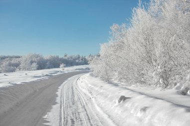 güneşli bir günde güzel kış karlı yol. Açık mavi gökyüzü