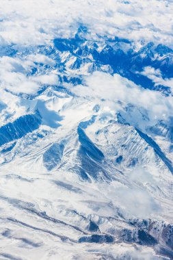 Uçuş sırasında uçak penceresinden dağların görüntüsü.