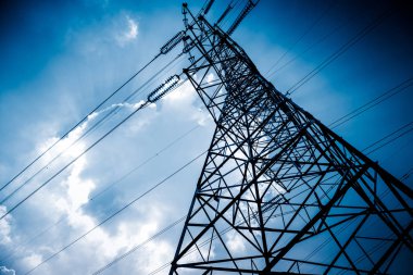 Gökyüzü arkaplanlı yüksek voltaj kuleleri. mavi tonlu resimler.